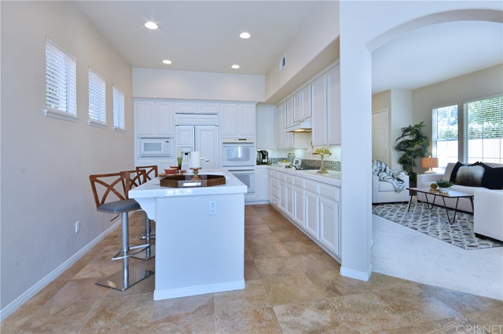 3619 Cll Joaquin Calabasas, CA 91302 - Photo 23 of 42 a kitchen with kitchen island stainless steel appliances a sink a counter top space and living room view