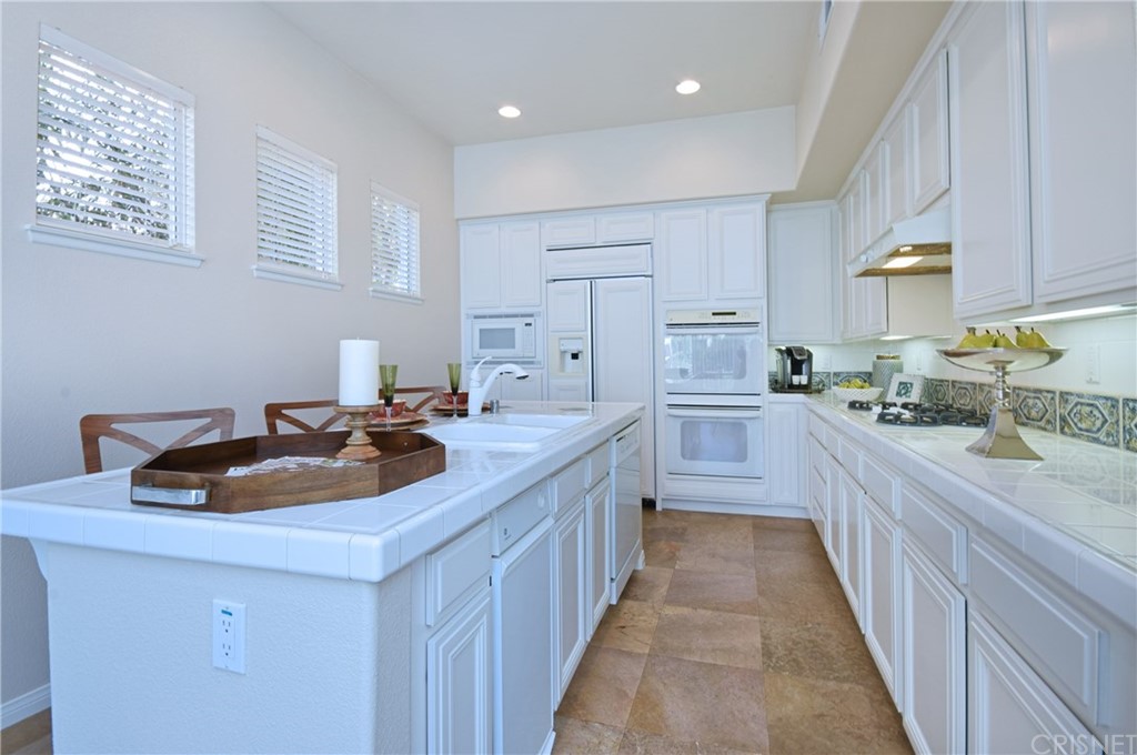 3619 Cll Joaquin Calabasas, CA 91302 - Photo 24 of 42 a kitchen with kitchen island granite countertop a sink and a refrigerator
