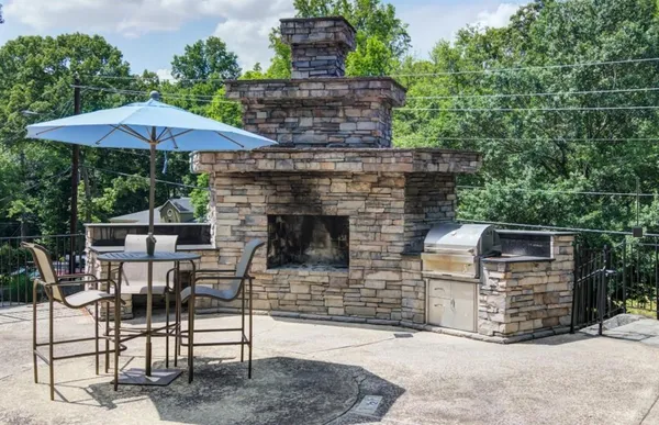 a view of a patio with table and chairs under an umbrella