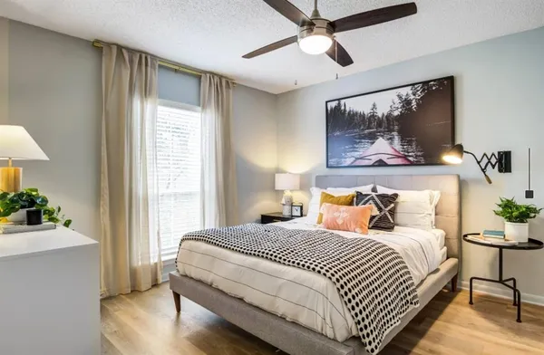 a bedroom with a large bed and a chandelier