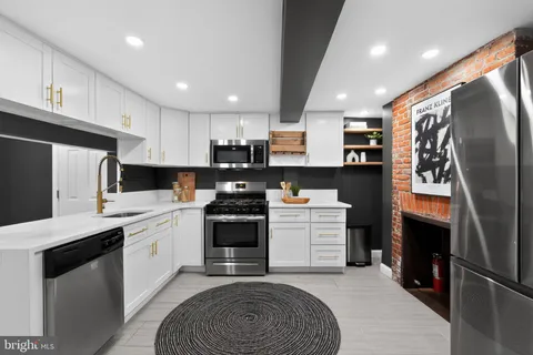 a kitchen with stainless steel appliances kitchen island granite countertop a refrigerator sink and cabinets