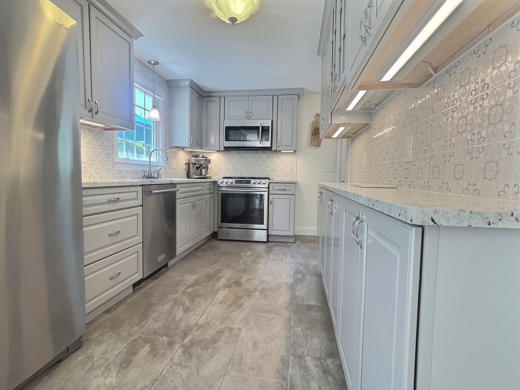 30 Edward Road Townsend, MA 01469 - Photo 5 of 42 a kitchen with stainless steel appliances granite countertop a stove top oven a sink dishwasher and a refrigerator with wooden floor