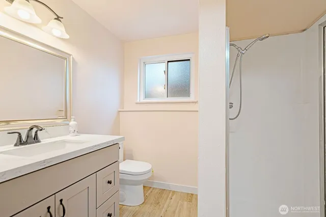 a bathroom with a sink a toilet and shower