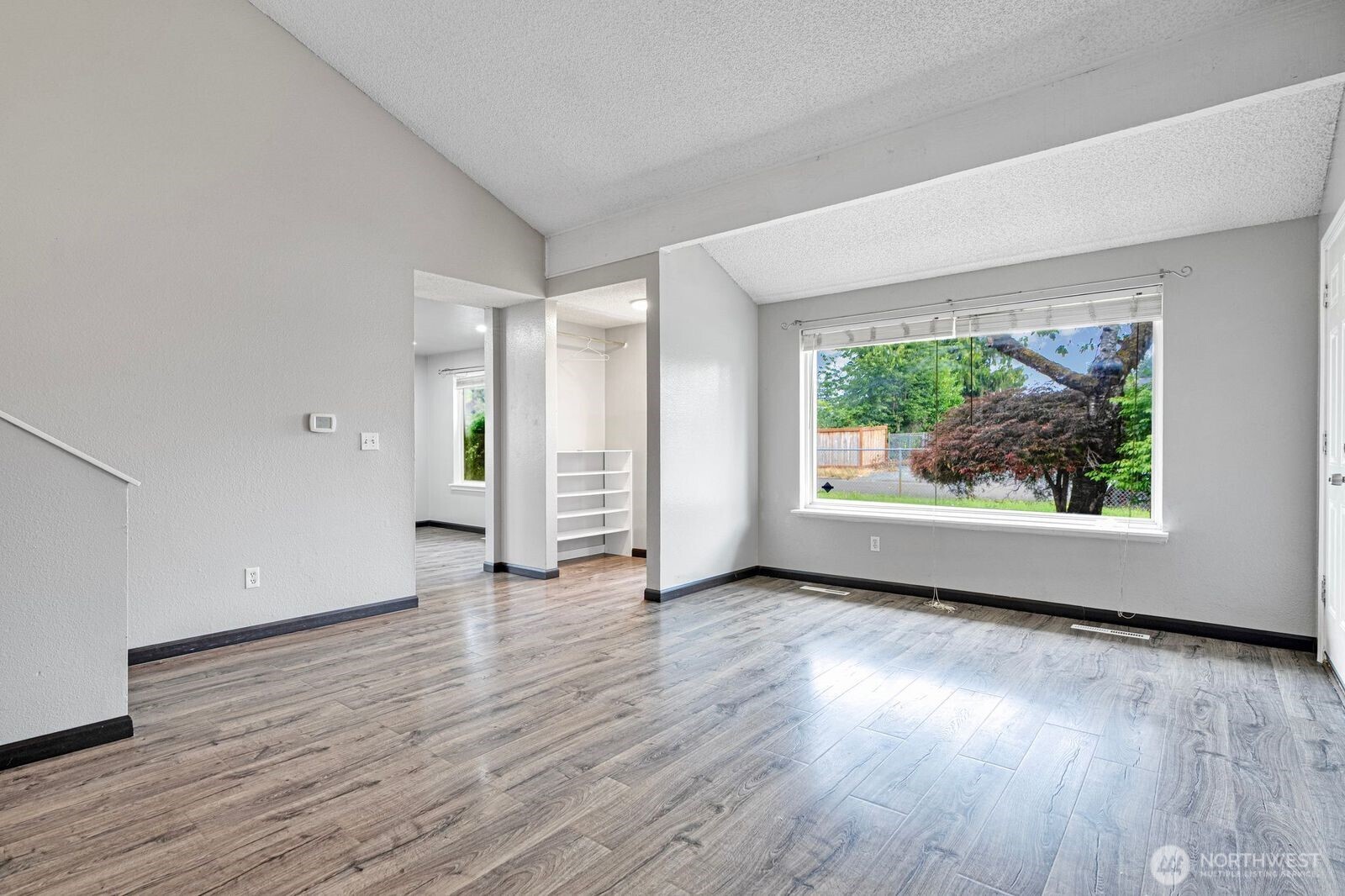 1102 156th Street East Tacoma, WA 98445 - Photo 8 of 20 an empty room with wooden floor and windows