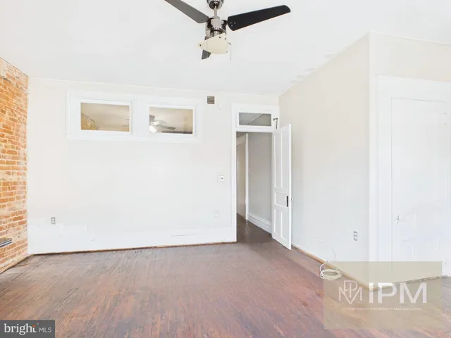 a view of a hallway with wooden floor and entryway