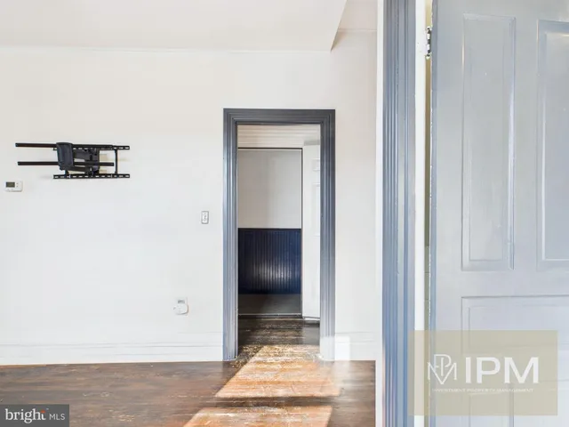 a view of a hallway with wooden floor and a cabinet