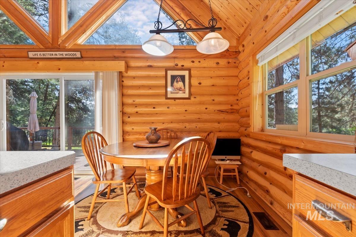 10 Elk Point Road Garden Valley, ID 83622 - Photo 14 of 42 Dining room with log walls, healthy amount of natural light, vaulted ceiling, and light wood finished floors