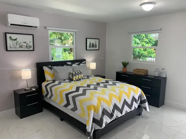 a bed sitting in a bedroom next to a window