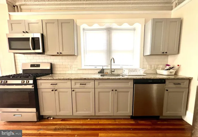 a kitchen with stainless steel appliances granite countertop a sink stove and microwave