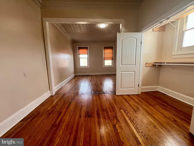 a view of empty room with wooden floor