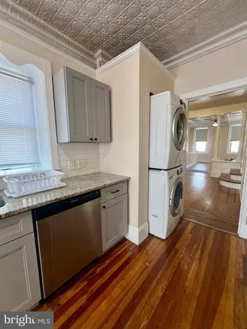 a kitchen with granite countertop a refrigerator a stove and wooden floor