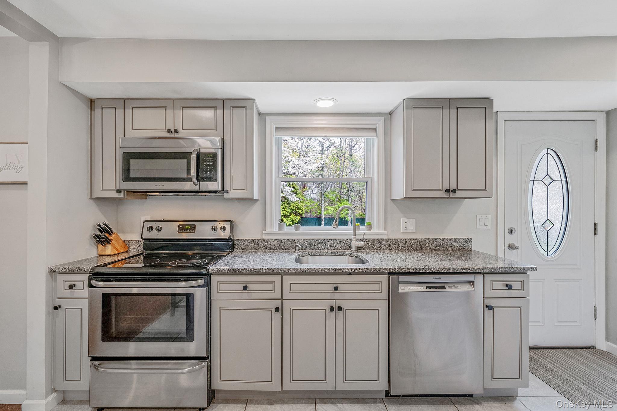 19 Pumpkin Road St. James, NY 11780 - Photo 11 of 35 a kitchen with granite countertop a stove a sink and a microwave