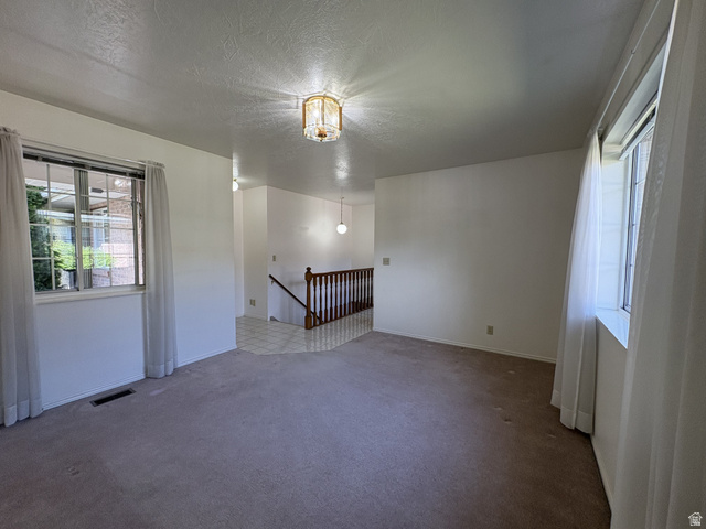 486 West 120 North Orem, UT 84057 - Photo 4 of 30 Spacious room with plush carpeting, multiple windows providing natural light, and a classic-style ceiling light fixture