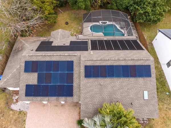 a view of a swimming pool with a patio and a wooden fence