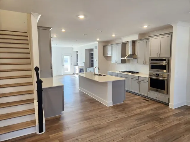 a kitchen with stainless steel appliances granite countertop a sink stove and refrigerator