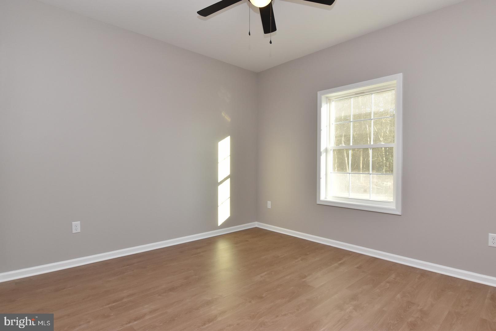 34327 Branch School Road Laurel, DE 19956 - Photo 16 of 23 an empty room with a window and a ceiling fan