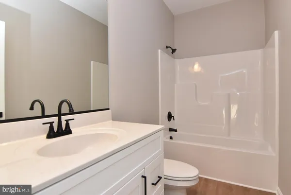 a bathroom with a sink a toilet and a large mirror