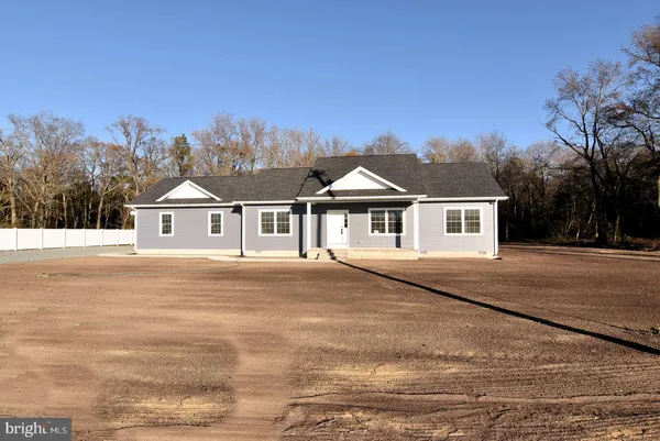 a front view of a house with a yard and trees