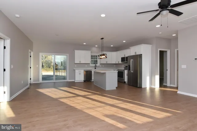 a view of kitchen with stainless steel appliances refrigerator stove microwave and cabinets