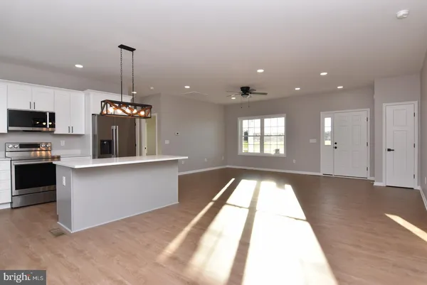 a view of an empty room and kitchen view