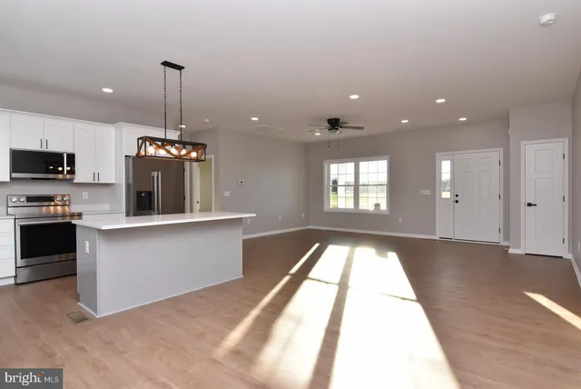 a view of an empty room and kitchen view