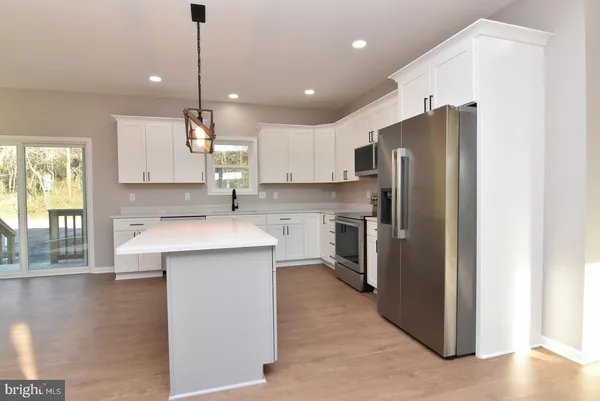 a kitchen with kitchen island a refrigerator a sink a stove a counter space and a window