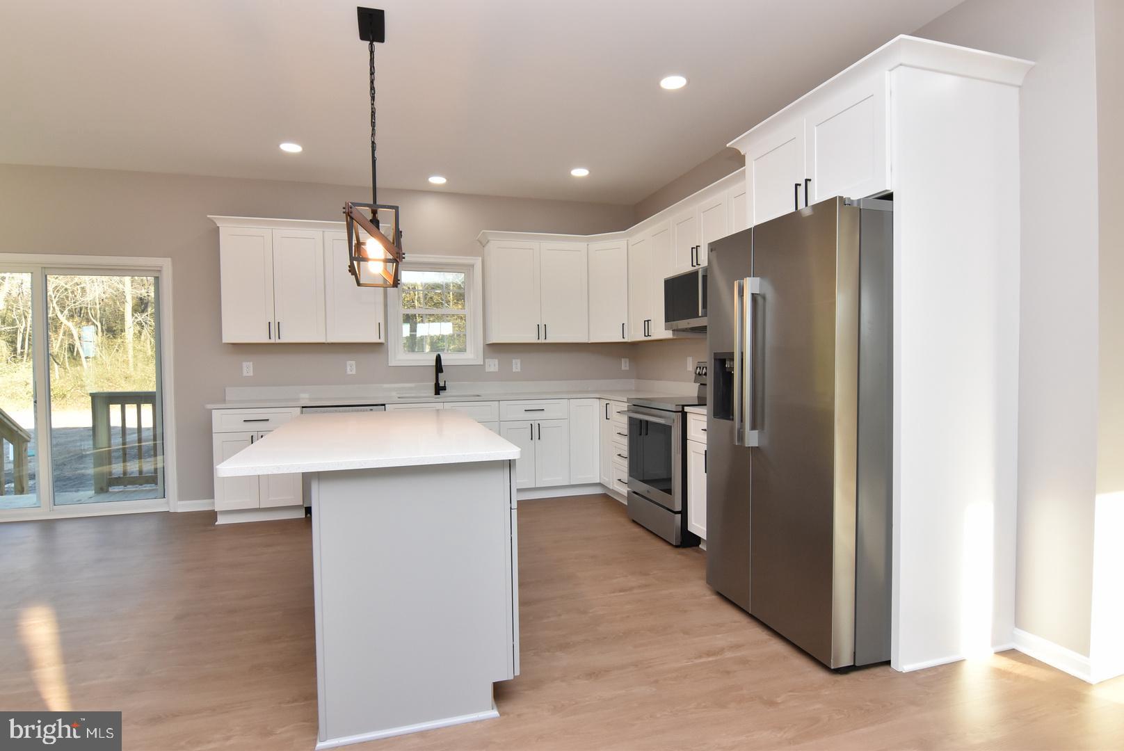 34327 Branch School Road Laurel, DE 19956 - Photo 6 of 23 a kitchen with kitchen island a refrigerator a sink a stove a counter space and a window