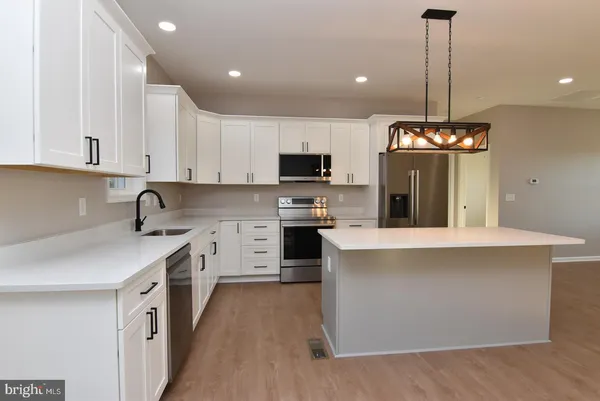a kitchen with stainless steel appliances a stove top oven and a sink