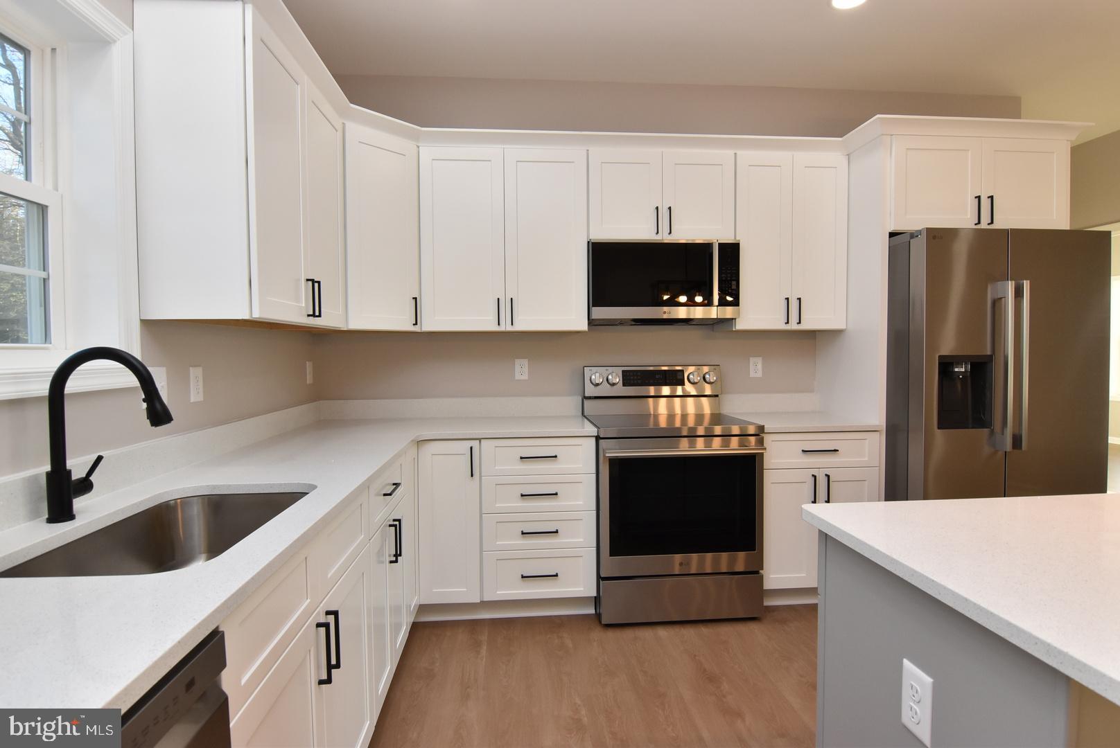 34327 Branch School Road Laurel, DE 19956 - Photo 8 of 23 a kitchen with stainless steel appliances a refrigerator sink and white cabinets