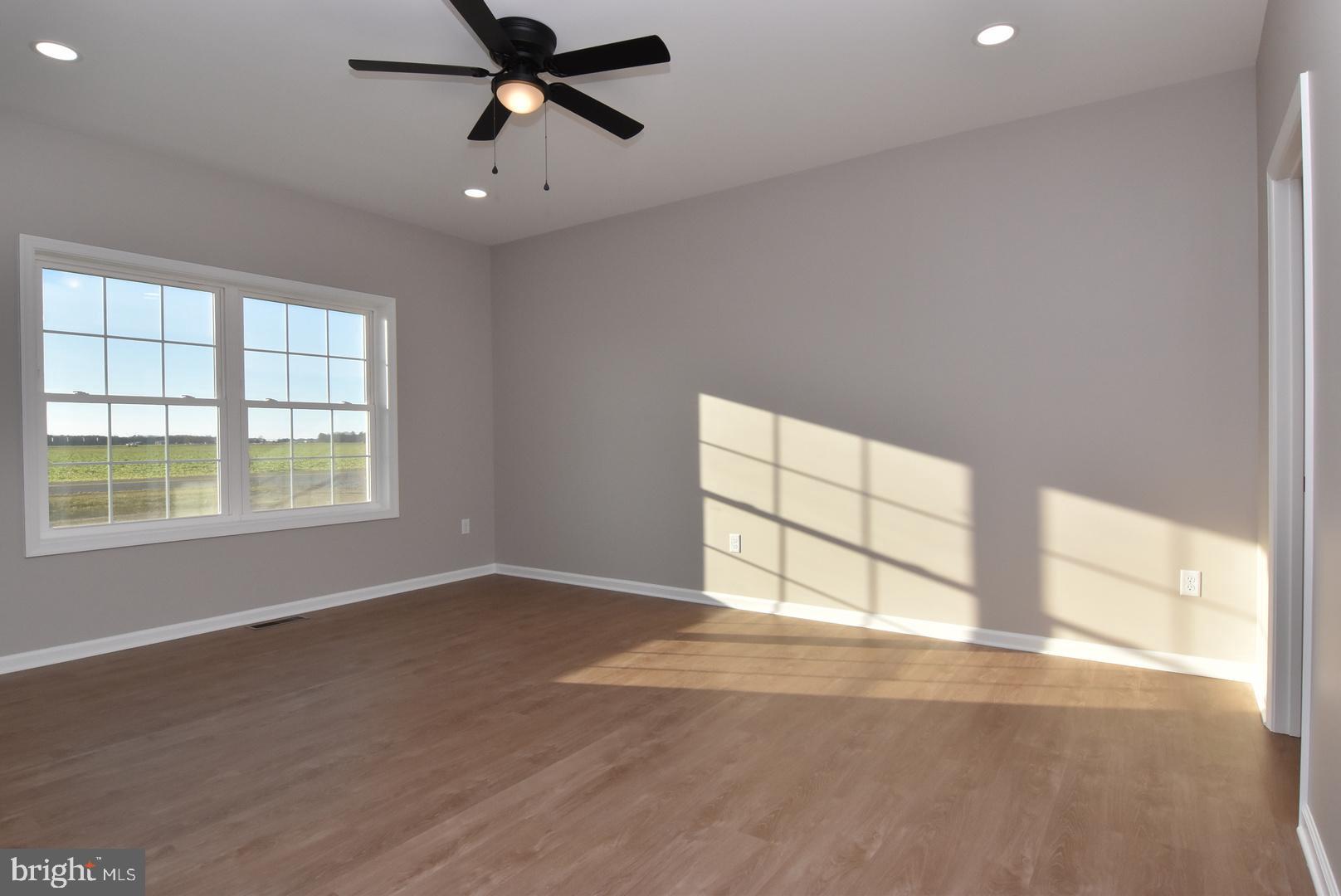 34327 Branch School Road Laurel, DE 19956 - Photo 10 of 23 an empty room with windows and ceiling fan