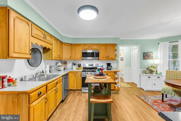 a kitchen with granite countertop a sink appliances cabinets and dining table chair