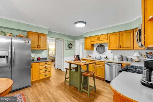 a kitchen with granite countertop stainless steel appliances a sink counter space and a window