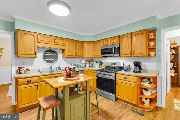 a kitchen with kitchen island granite countertop a sink cabinets and appliances