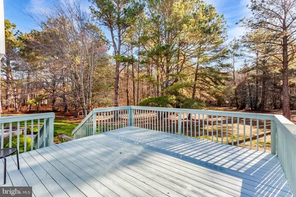 a view of a deck with two chairs and wooden floor
