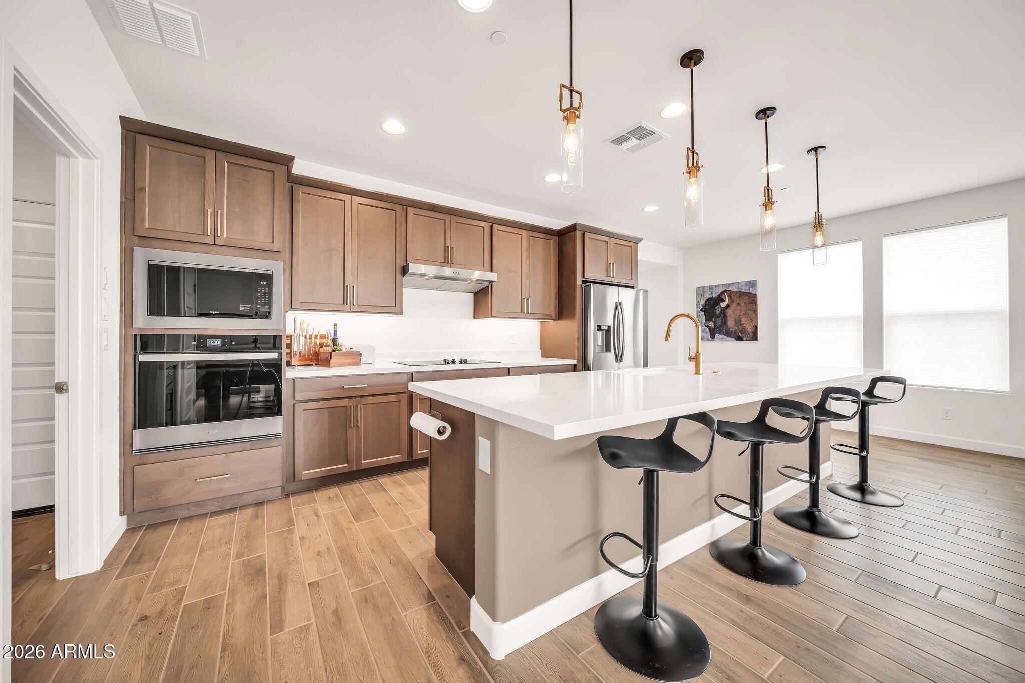 18221 East Spring Valley Court Rio Verde, AZ 85263 - Photo 10 of 49 a kitchen with granite countertop a wooden floor a center island stainless steel appliances and cabinets