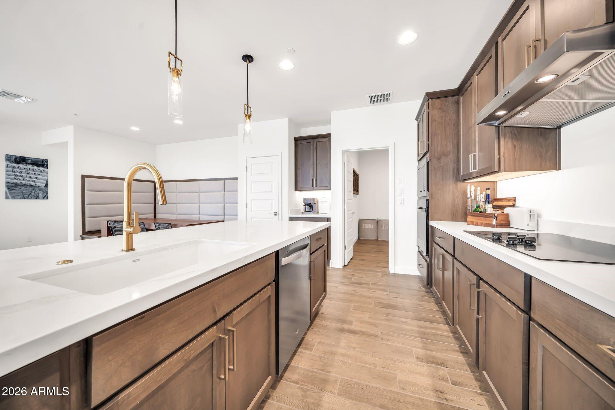 18221 East Spring Valley Court Rio Verde, AZ 85263 - Photo 12 of 49 a large kitchen with stainless steel appliances kitchen island granite countertop a sink and cabinets