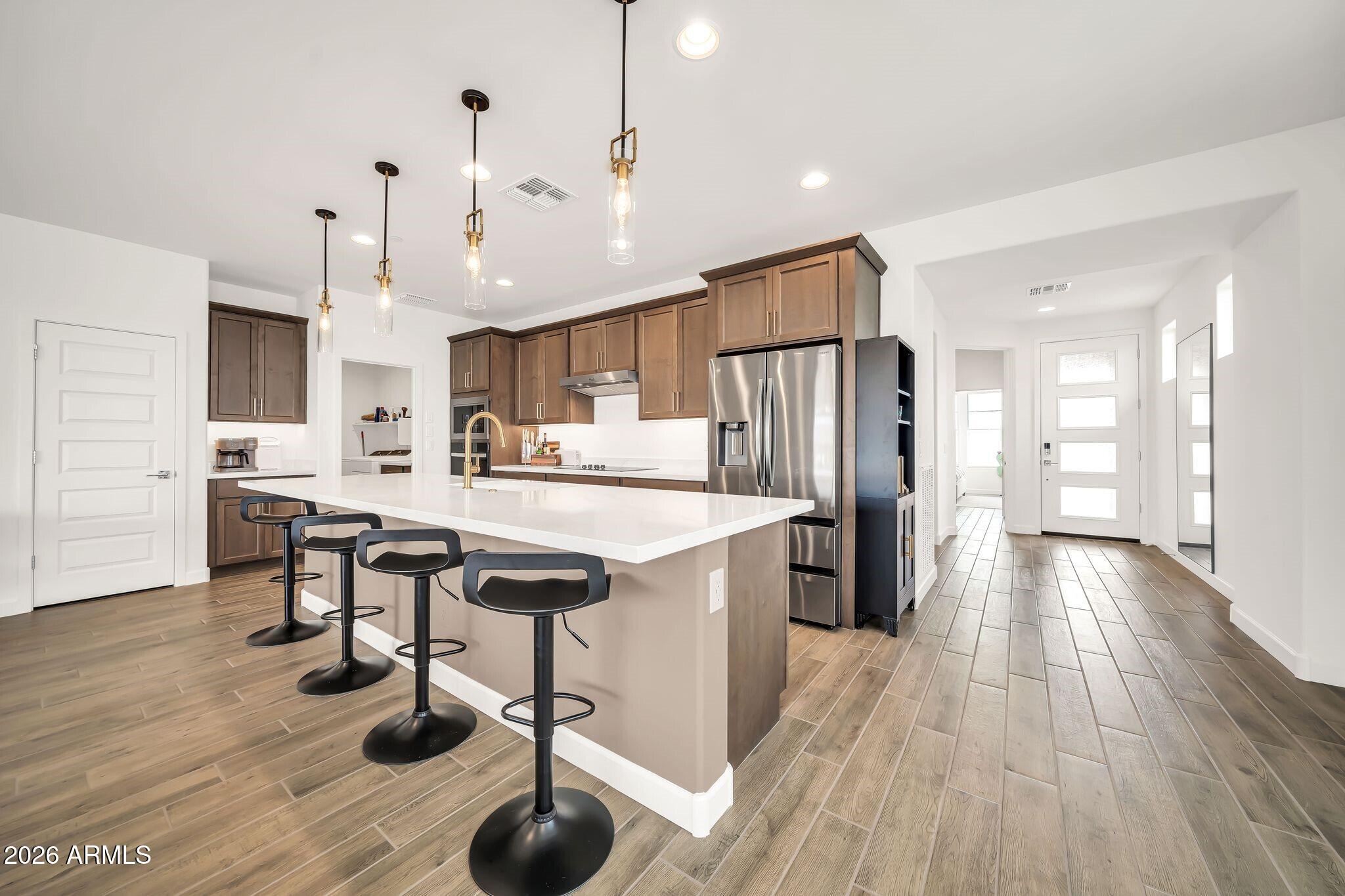 18221 East Spring Valley Court Rio Verde, AZ 85263 - Photo 8 of 49 a kitchen with stainless steel appliances granite countertop a refrigerator a sink dishwasher a stove and a dining table with wooden floor