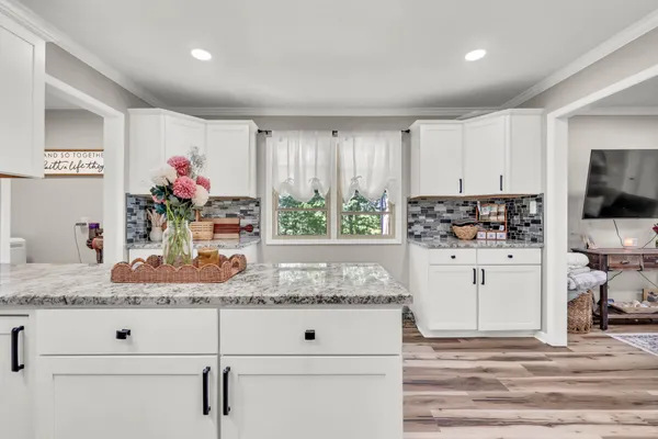 a kitchen with sink window and white cabinets