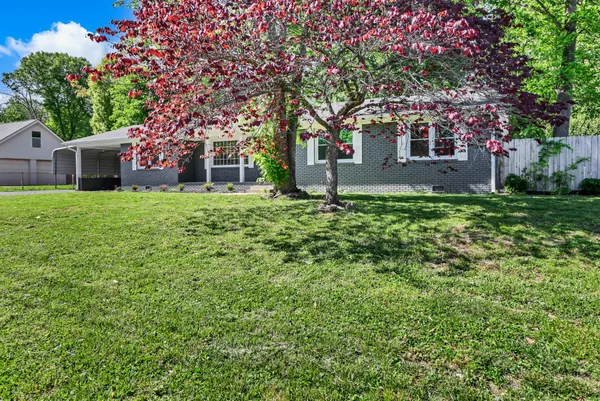 a house is sitting in middle od the grass