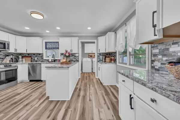 a kitchen with white cabinets and sink