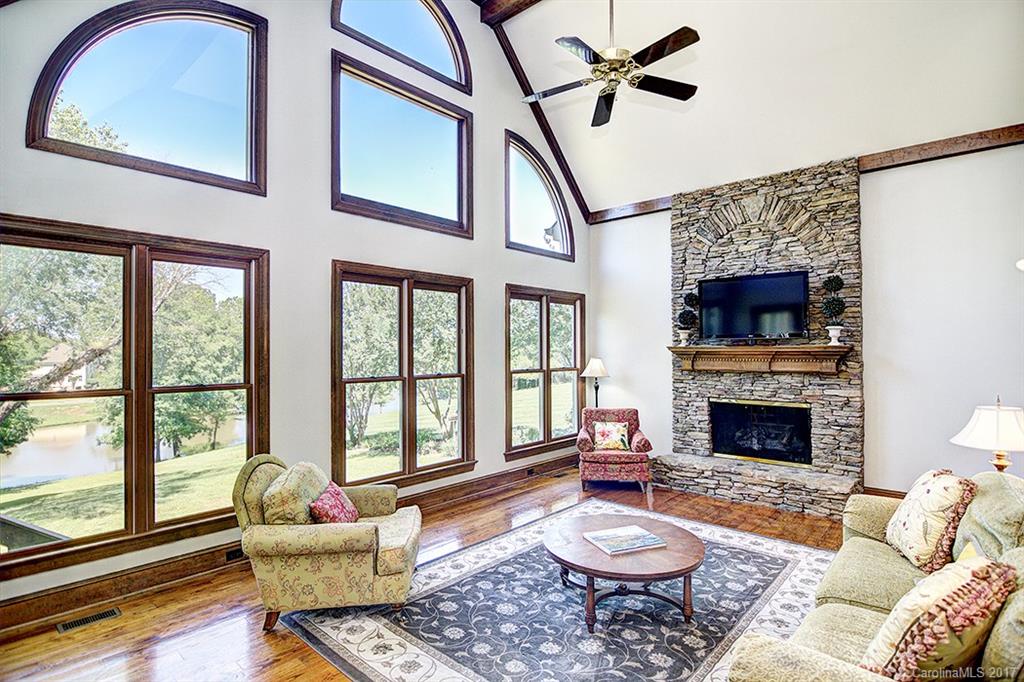 443 Beacon Knoll Lane Fort Mill, SC 29708 - Photo 12 of 24 a living room with furniture a fireplace and a floor to ceiling window