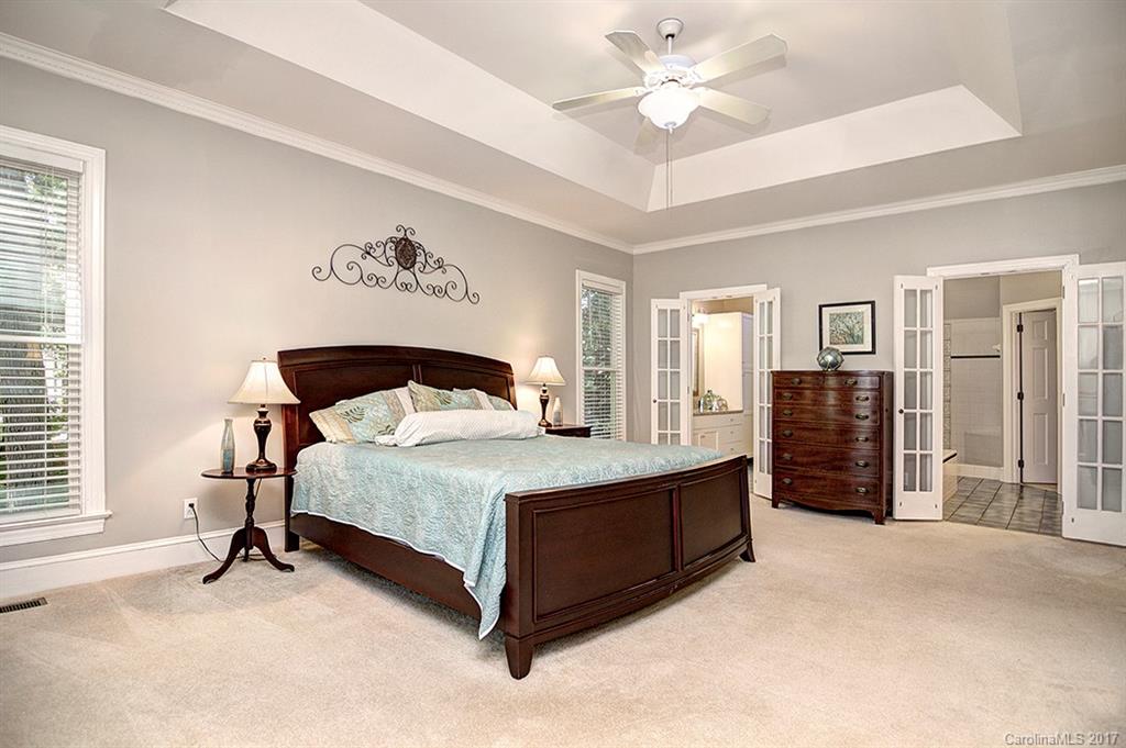 443 Beacon Knoll Lane Fort Mill, SC 29708 - Photo 14 of 24 a spacious bedroom with a bed and a chandelier