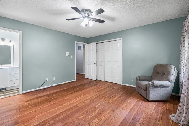 a bedroom with furniture and a chandelier fan