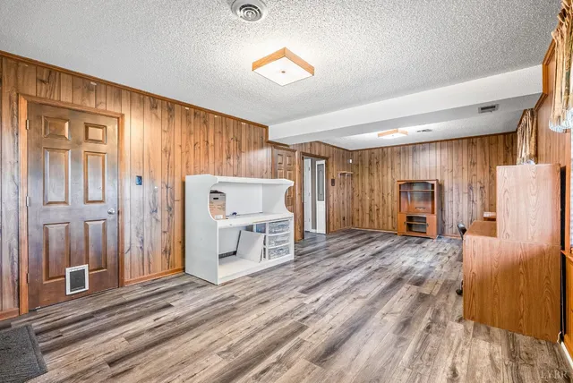 a living room with a bed and a refrigerator
