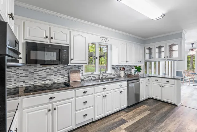 a kitchen with granite countertop white cabinets white stainless steel appliances and a sink