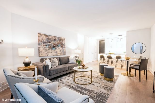 a living room with furniture a rug and a lamp