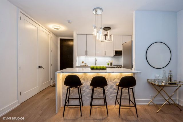 a view of kitchen with granite countertop microwave and sink