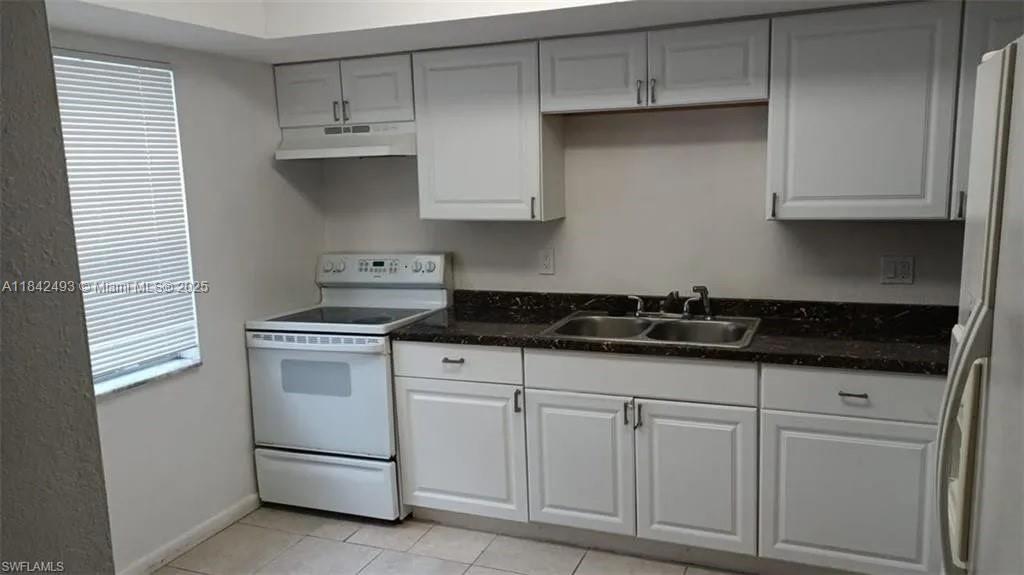 2524 Congress Street, Unit 4 Fort Myers, FL 33901 - Photo 11 of 24 a kitchen with white cabinets and white appliances