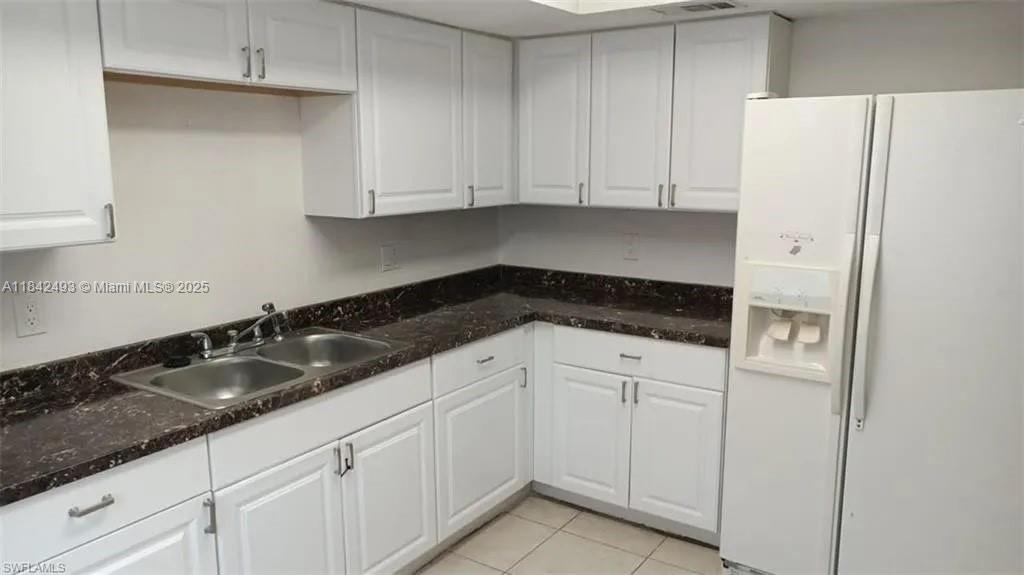 2524 Congress Street, Unit 4 Fort Myers, FL 33901 - Photo 9 of 24 a kitchen with granite countertop white cabinets and refrigerator