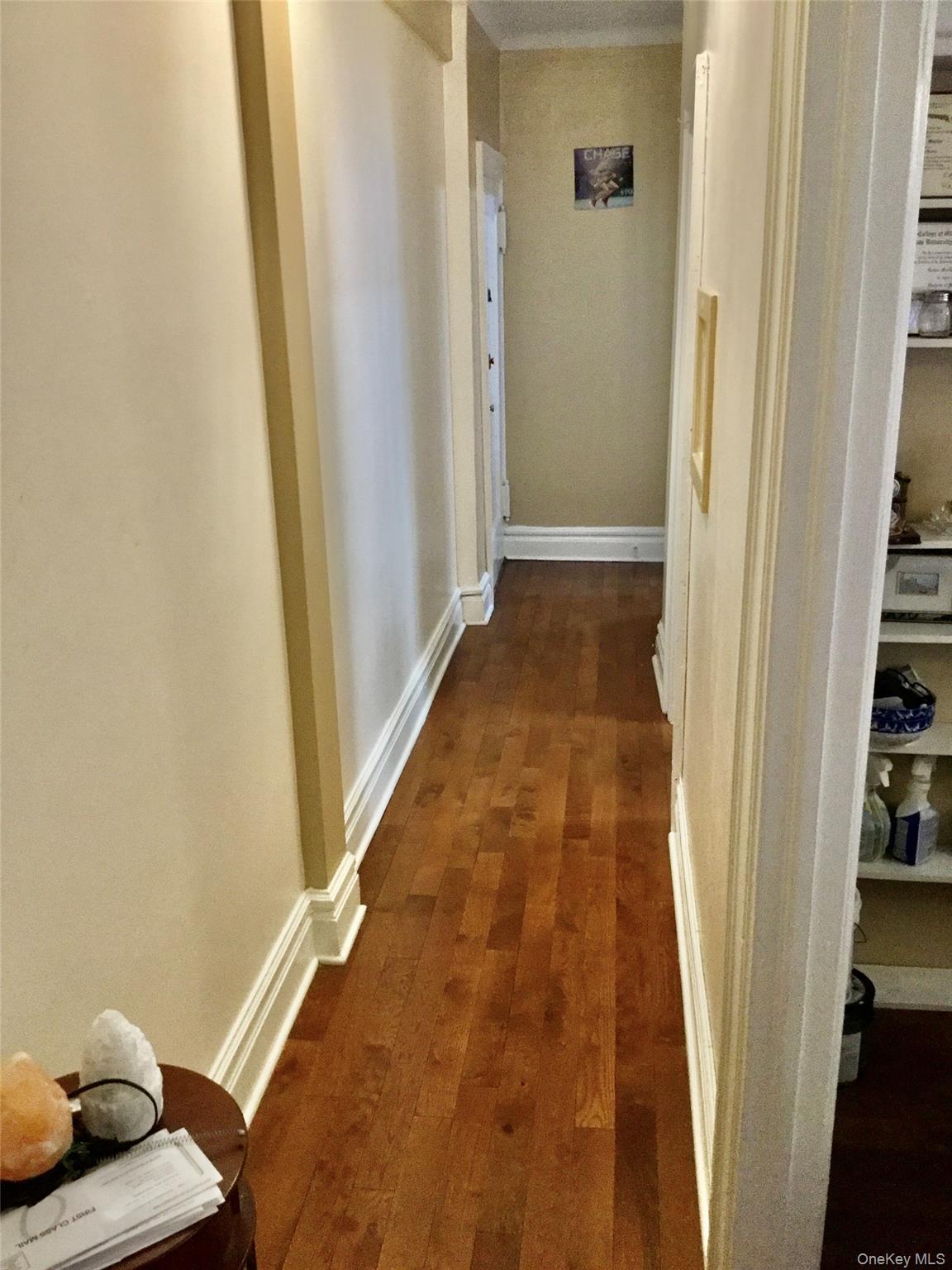 35-20 82nd Street, Unit 31J Queens, NY 11372 - Photo 6 of 10 Hall with dark wood finished floors and baseboards